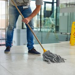 Hell leave that floor spotless. Shot of an unrecognizable man mopping the office floor